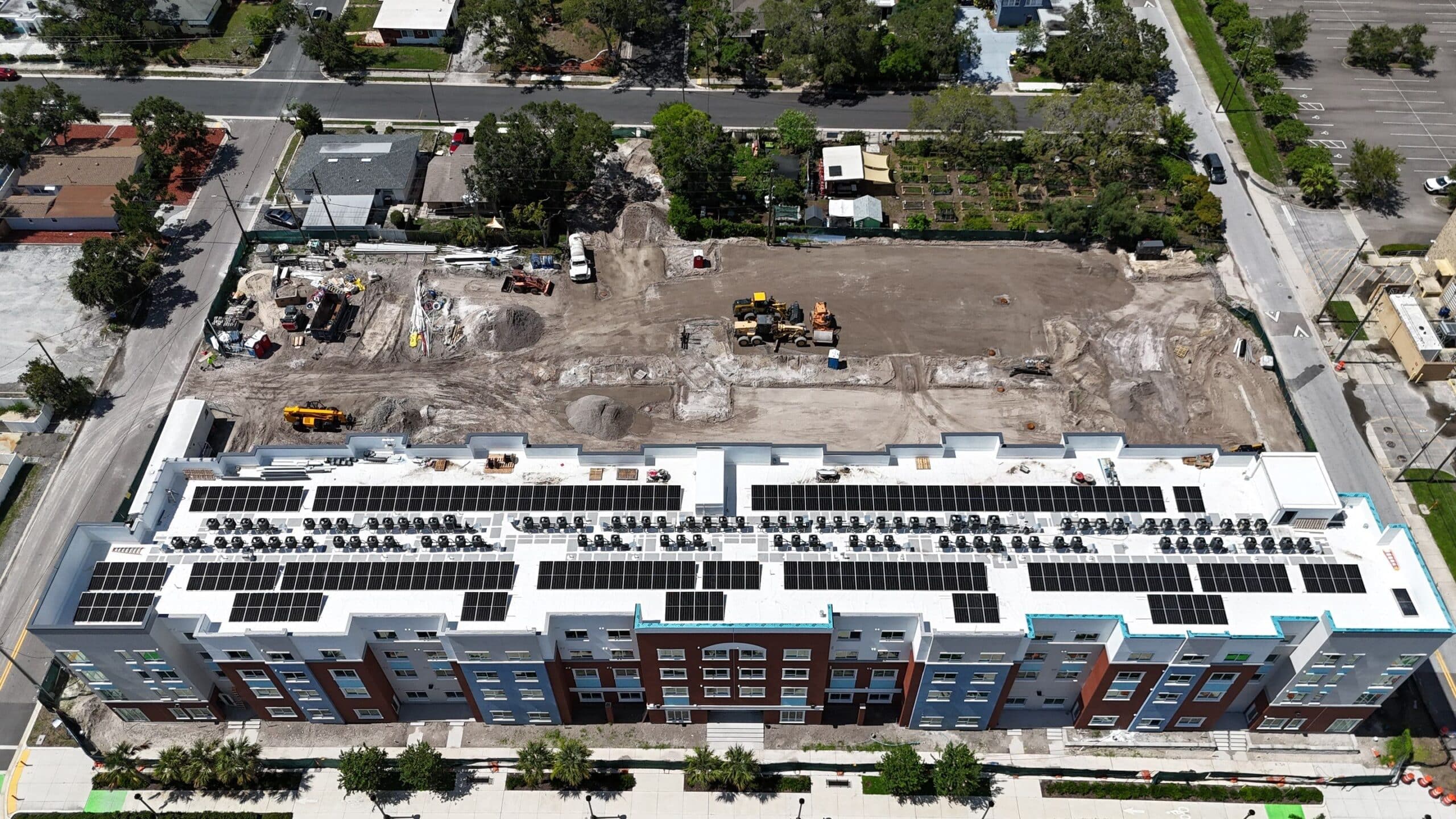 Aerial view of building with solar panels, construction site.