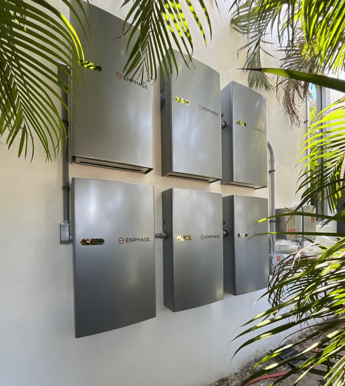Enphase battery storage units installed on a wall outdoors.